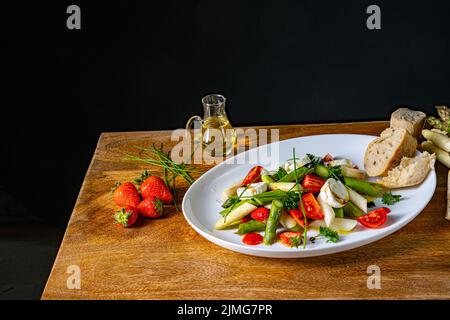 Insalata di asparagi con fragole, pomodori e formaggio di capra Foto Stock