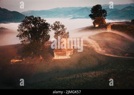 Paesaggio rurale di prima mattina con nebbia in montagna Foto Stock