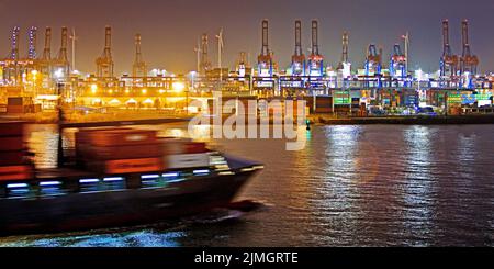 Nave portacontainer di fronte alle gru di carico presso il terminal dei container Burchardkai di notte, Amburgo Foto Stock