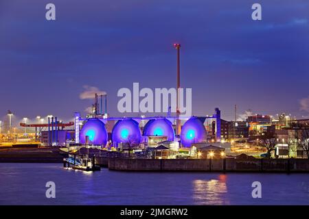 Impianto di depurazione illuminato blu Koehlbrandhoeft n la sera, porto di Amburgo, Germania Foto Stock