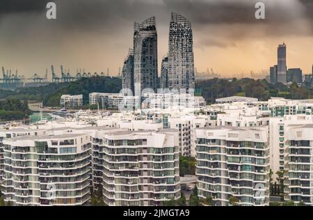 Top of immobiliare case nel centro di Singapore, pochi grattacieli sullo sfondo, cielo tempesta al tramonto Foto Stock