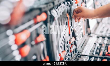 negozio di attrezzi mostra il lavoratore che sceglie gli strumenti Foto Stock