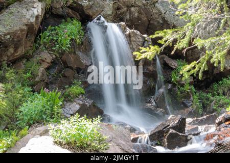 Una cascata scende lungo il lato di una montagna nelle Montagne Rocciose del Colorado Foto Stock