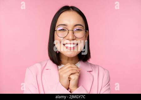 Primo piano ritratto di sorridente felice businesswoman in occhiali, clench mani insieme grato, eccitato di smth, implorando o dire il ple Foto Stock