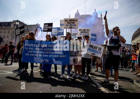 Londra, Regno Unito. 06th ago 2022. Un gruppo di attivisti del PETA ha visto con i loro cartelli a sostegno dei diritti degli animali e della luce fumosa durante la manifestazione. Gli attivisti per i diritti degli animali si sono riuniti e hanno marciato nel centro di Londra. Gli attivisti hanno spiegato i legami tra la crisi climatica e i diritti degli animali e hanno organizzato questo marzo come parte della campagna per il futuro delle piante. Credit: SOPA Images Limited/Alamy Live News Foto Stock