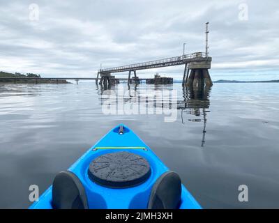 Kayak blu che si avvicina al molo di Inverkip sul Firth di Clyde Foto Stock