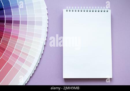 Campioni di vernice, campione multicolore per il design degli interni. Rosso, rosa, viola e viola con colori lilla. Sfondo lilla chiaro. Carta bianca per notebook f Foto Stock