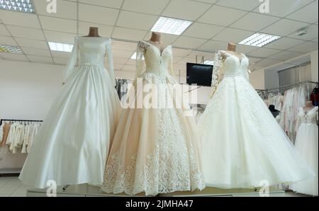 Tre eleganti abiti da sposa su manichini. Tre diversi modelli di splendidi abiti da sposa. Foto Stock