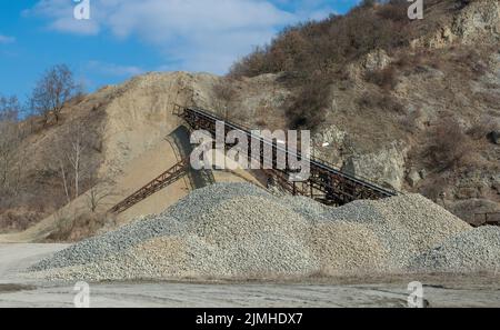 Nastro trasportatore in una vecchia cava di ghiaia. Attrezzature per estrazione mineraria e cava. Foto Stock