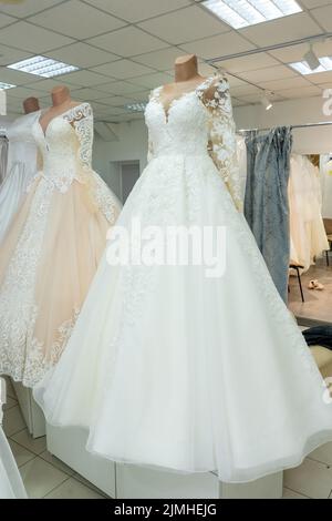 Splendidi abiti da sposa in una boutique nuziale su manichini. Foto Stock