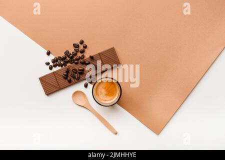 Caffè in grani arrosto, barretta di cioccolato, bicchiere con cucchiaio di fondo Foto Stock