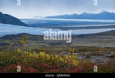 Splendida vista autunnale dal canyon di Mulagljufur al ghiacciaio di Fjallsarlon con la laguna ghiacciata di Breidarlon, Islanda. Non lontano dalla circonvallazione Foto Stock