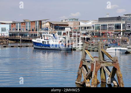 Baia di Cardiff con barca Sea Cadets ormeggiata a un pontile. Un'antica struttura di ormeggio in legno chiamata delfino in primo piano. Data di agosto 2022. Estate Foto Stock