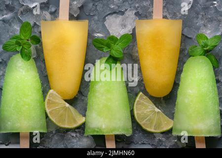 Popsicles fatti in casa con succo di lime, menta e ghiaccio d'arancia lolly Foto Stock