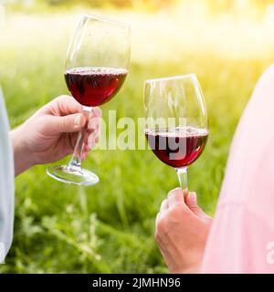 Wineglasses con vino rosso mani pic-nic coppia Foto Stock