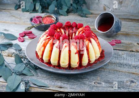 Budino tradizionale italiano di ricotta cheesecake con crÃ¨me di cioccolato e guarnizione di lampone servito come primo piano su a des Foto Stock