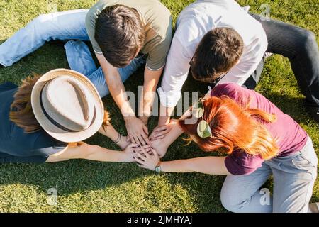 Gruppo di amici adulti mettendo le mani insieme Foto Stock