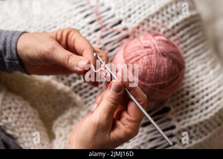 Persona in alta vista che si unisce con filo rosa Foto Stock