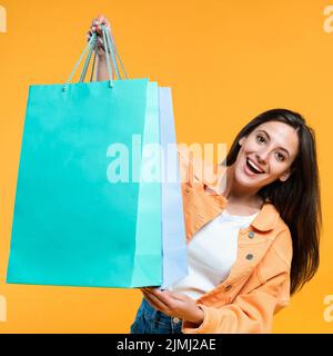 Donna eccitata che tiene su borse di shopping molto Foto Stock