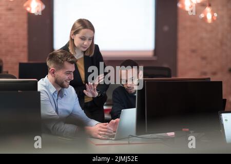 La squadra di gente di affari con esperienza nel lavoro sul progetto di affari che istruisce il collega dell'uomo, consulente qualificato della signora piacevole Foto Stock