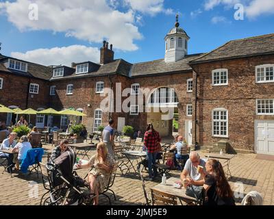 Le persone si gustano i loro drink in un bar nel Temple Newsam Park, nel West Yorkshire, in una bella giornata estiva Foto Stock