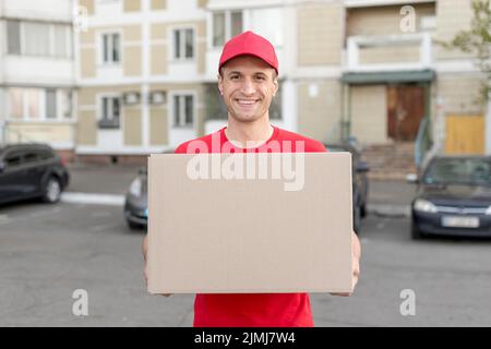 Sorridente che consegna il pacchetto Foto Stock