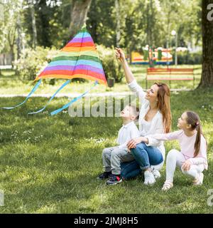 Madre figli che giocano con aquilone Foto Stock