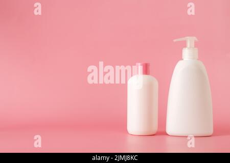 Cosmetici, idratante, bottiglia. Bottiglie cosmetiche diverse. Set di prodotti cosmetici su sfondo rosa. Confezione cosmetica per crema, zuppe, Foto Stock