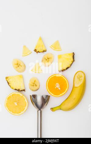 Frullatore elettrico con fette di ananas banana arancio isolato sfondo bianco Foto Stock