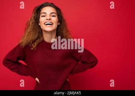 Foto di bella giovane donna sorridente allegra vestito casual alla moda in piedi isolato su sfondo colorato w Foto Stock