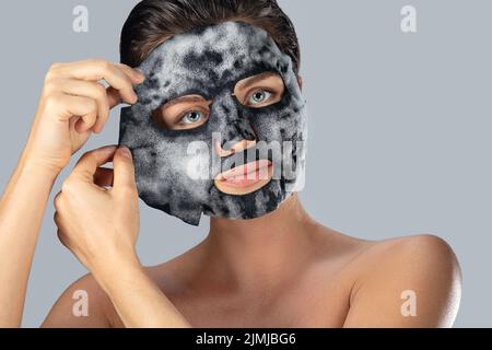 Donna con maschera bolla foglio sul suo viso Foto Stock