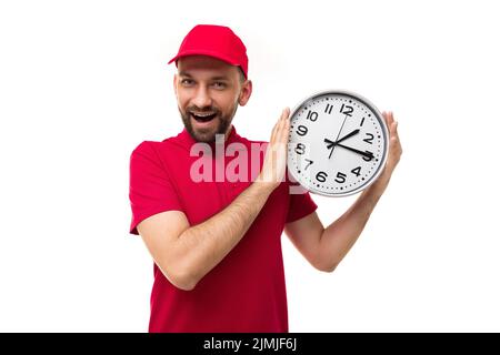 Concetto di consegna rapida in breve, scadenze corriere in uniforme rossa su sfondo bianco con un grande orologio nelle sue mani Foto Stock