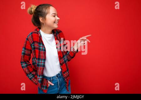 Ritratto di giovane attraente positivo felice ridendo sorridente ragazza bionda hipster in elegante camicia rossa e casual t-shirt bianca. Foto Stock