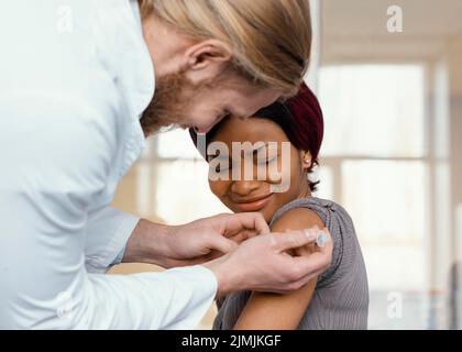 Primo piano donna che viene vaccinata Foto Stock