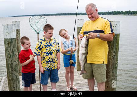 Newport News Virginia, James River Water pesca porto ricreativo molo, famiglia ragazzi ragazza fratelli sorella nonno tenendo pesce catturato vacanza Foto Stock