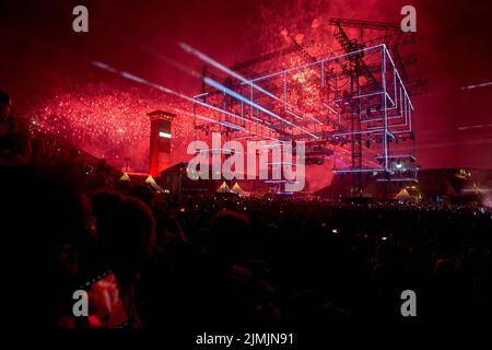 Kastellaun, Germania. 07th ago 2022. I rovers ballano al festival techno 'Nature One' mentre i fuochi d'artificio sono sparati sopra di loro. Il festival sull'ex base missilistica americana di crociera a Hunsrück non poteva aver luogo per due anni a causa della pandemia. Quest'anno gli organizzatori si aspettano circa 60000 visitatori. Credit: Thomas Frey/dpa/Alamy Live News Foto Stock