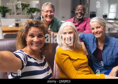 Allegro multirazziale senior maschile e femminile amici che prendono selfie insieme a casa Foto Stock