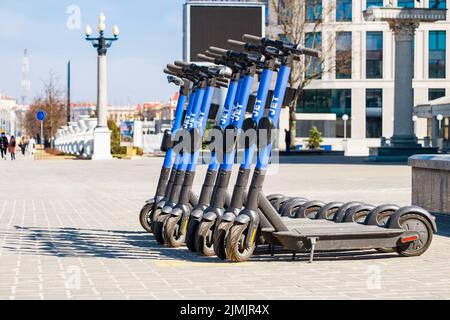 Una fila di SCOOTER ELETTRICI A GETTO è pronta per il viaggio. Affitto. Esplora. Divergetevi. Foto Stock