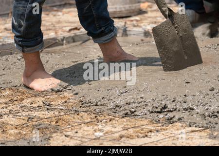 Costruzione non sicura dei lavoratori migranti Myanmar mentre versano soletta di cemento in cantiere , Thailandia. Foto Stock