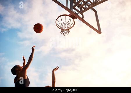 Spingermi al limite. Uno sportivo irriconoscibile che blocca il suo avversario durante una partita di basket durante il giorno. Foto Stock