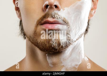 Uomo con una crema da barba sul viso Foto Stock