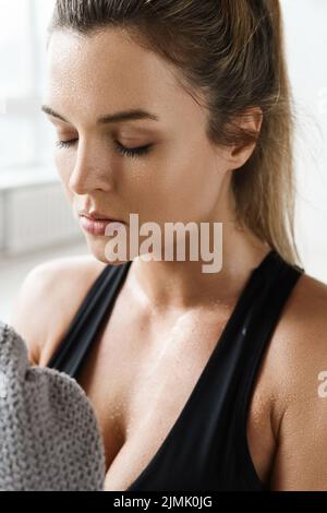 Donna stanca con un asciugamano dopo l'allenamento in palestra Foto Stock