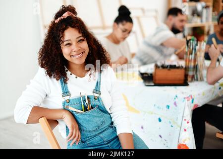 Ogni artista era una volta un dilettante. Ritratto corto di una giovane donna attraente seduta con i suoi amici durante una classe d'arte in studio. Foto Stock