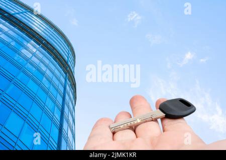 Chiave per porta in metallo in mano di un uomo. Vendita e affitto di immobili. Foto Stock