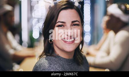 La vigilia di Natale non sarebbe la stessa senza una festa. Ritratto di una giovane donna che ha una cena con gli amici a casa. Foto Stock