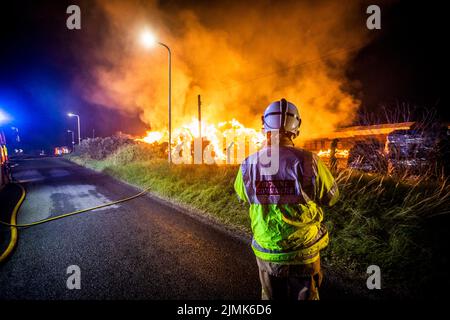 Portadown, County Armagh, Irlanda del Nord, domenica 7th agosto, 2022 - il comandante dell'incidente dal servizio di soccorso e fuoco dell'Irlanda del Nord osserva da un punto di vista privilegiato dopo che un fuoco importante è scoppiato intorno a Capper Trading LTD sulla strada di Tannaghmore in ritardo nella notte di sabato 6th agosto, accreditamento: Notizie dal vivo di Conor Kinahan/Alamy Foto Stock