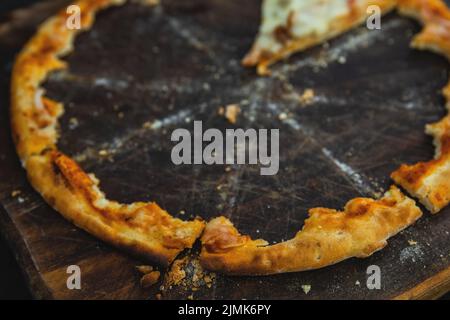 Croste croccanti di deliziosa pizza sul bordo di legno Foto Stock