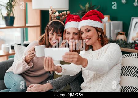 Potrebbe essere migliore. Tre donne attraenti che prendono i selfes di Natale insieme nel paese. Foto Stock