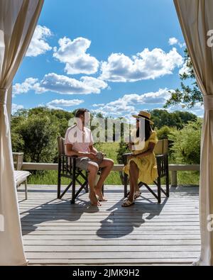 Coppia uomini e donne di fronte a tenda safari su un safari di lusso, Sud Africa, safari di lusso Lodge nel cespuglio Foto Stock