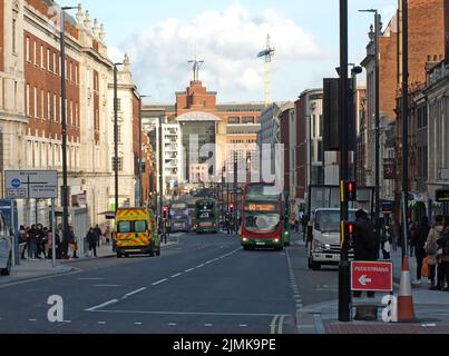 Traffico autobus e persone sulla headrow a leeds con la cava casa in fondo alla strada Foto Stock